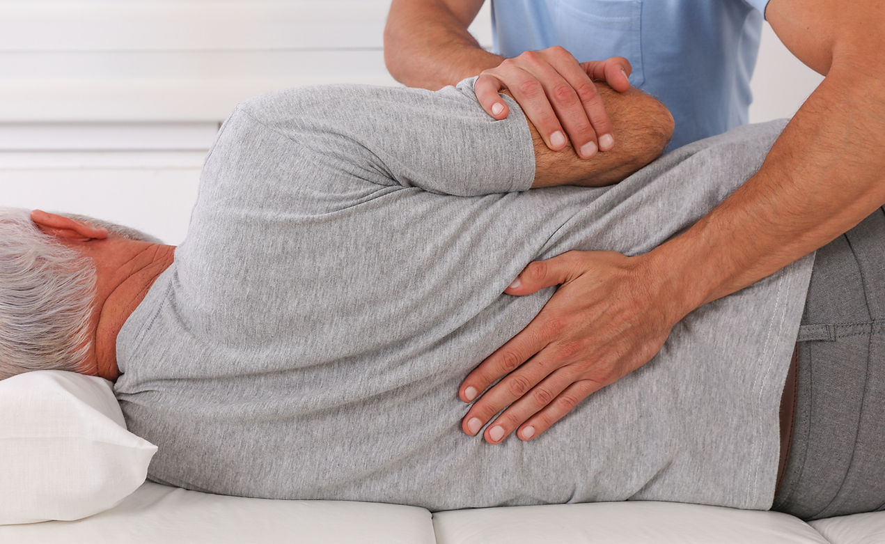 A man receives a therapeutic back massage from a professional physical therapist in a calming environment.